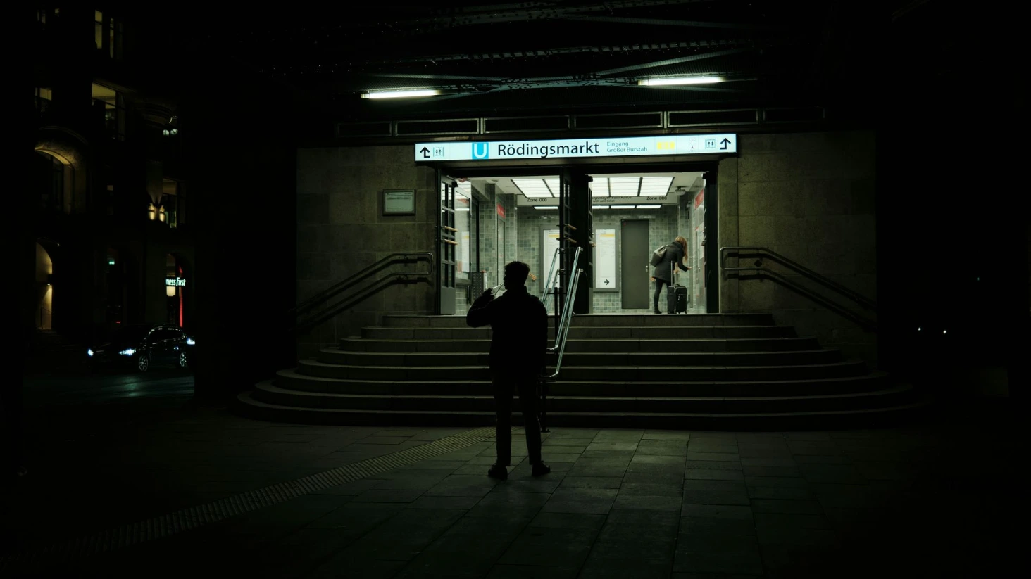 Un homme la nuit devant un métro